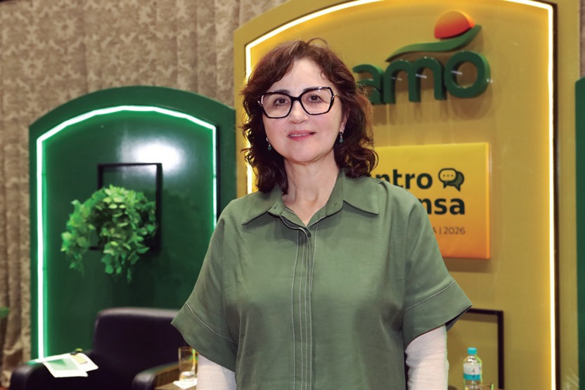 Jussara Harmuch, de blusa verde e &oacute;culos, diante do painel do Encontro com a Imprensa