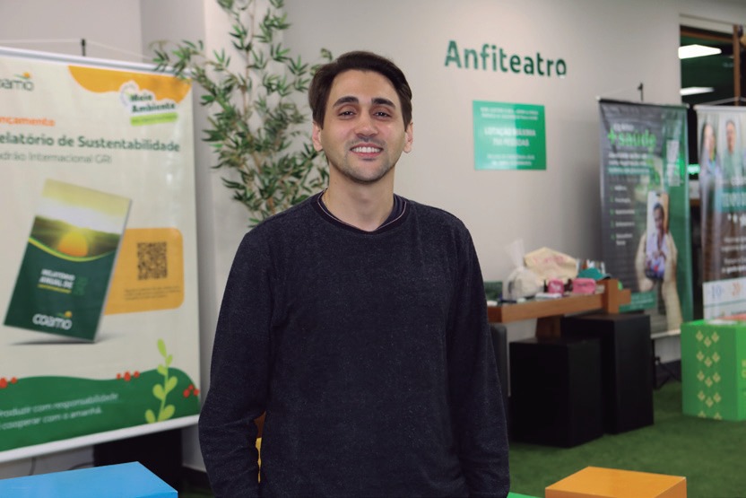 Paulo Henrique Santhias, de blusa escura, diante do painel do anfiteatro