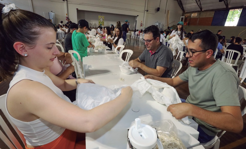 Volunt&aacute;rios montando fraldas em mesa no gin&aacute;sio