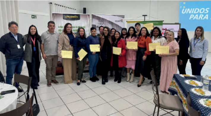 Foto em grupo de formandos do curso de panificação, segurando certificados.