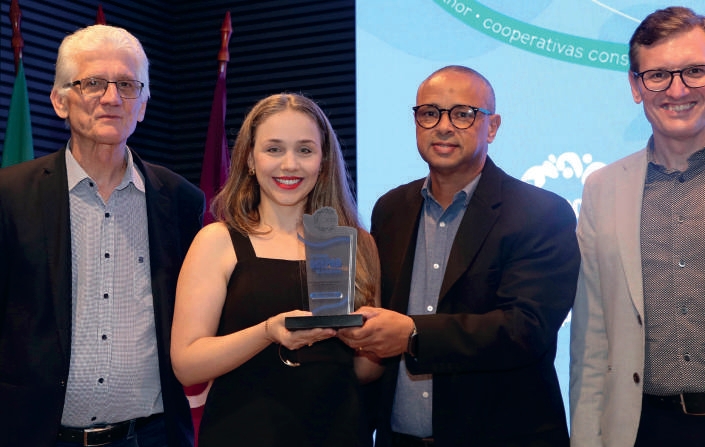 Ana Paula Pelissari e Wilson Bibiano recebendo o pr&ecirc;mio no palco