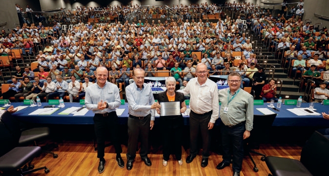 Dalva Caramalac recebendo placa de homenagem de diretores da Coamo