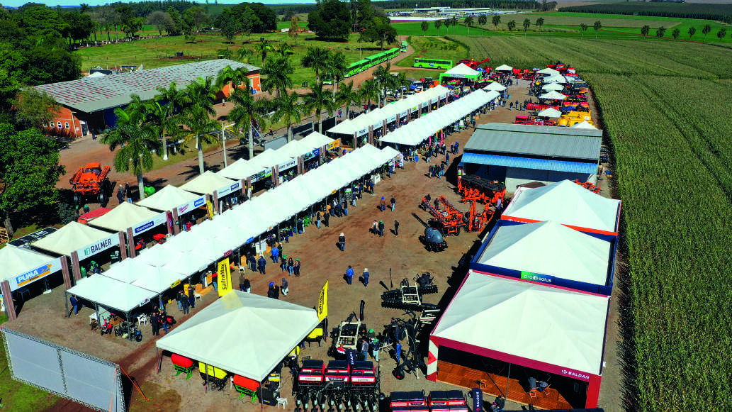 Vista aérea da Feira de Negócios, com estandes e máquinas agrícolas expostos.