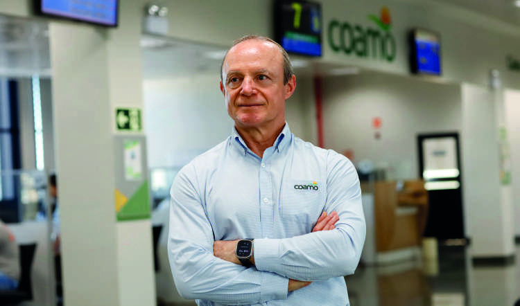 Airton Galinari, presidente Executivo da Coamo, de braços cruzados em um escritório.