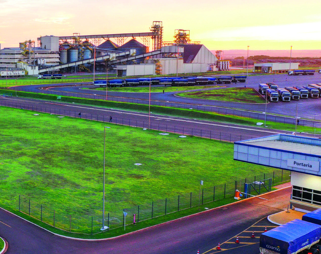Vista das instalações da indústria da Coamo em Dourados, mostrando silos e prédios de processamento.