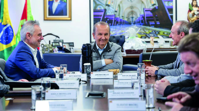Vista aérea de um píer com dois navios graneleiros atracados para operação de carga e descarga.