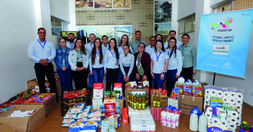 Grupo de funcionários da Coamo com alimentos arrecadados para doação.
